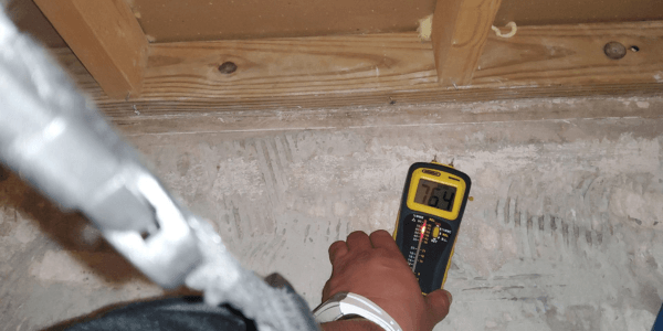 moisture meeter being used to discover Causes of Water Damage